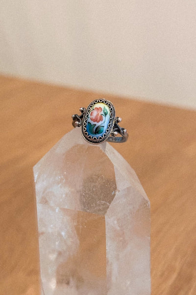 Ring with a floral design on a crystal on a wooden surface