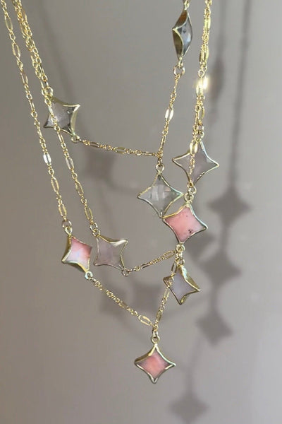 Necklace with star-shaped pendants on a gray background