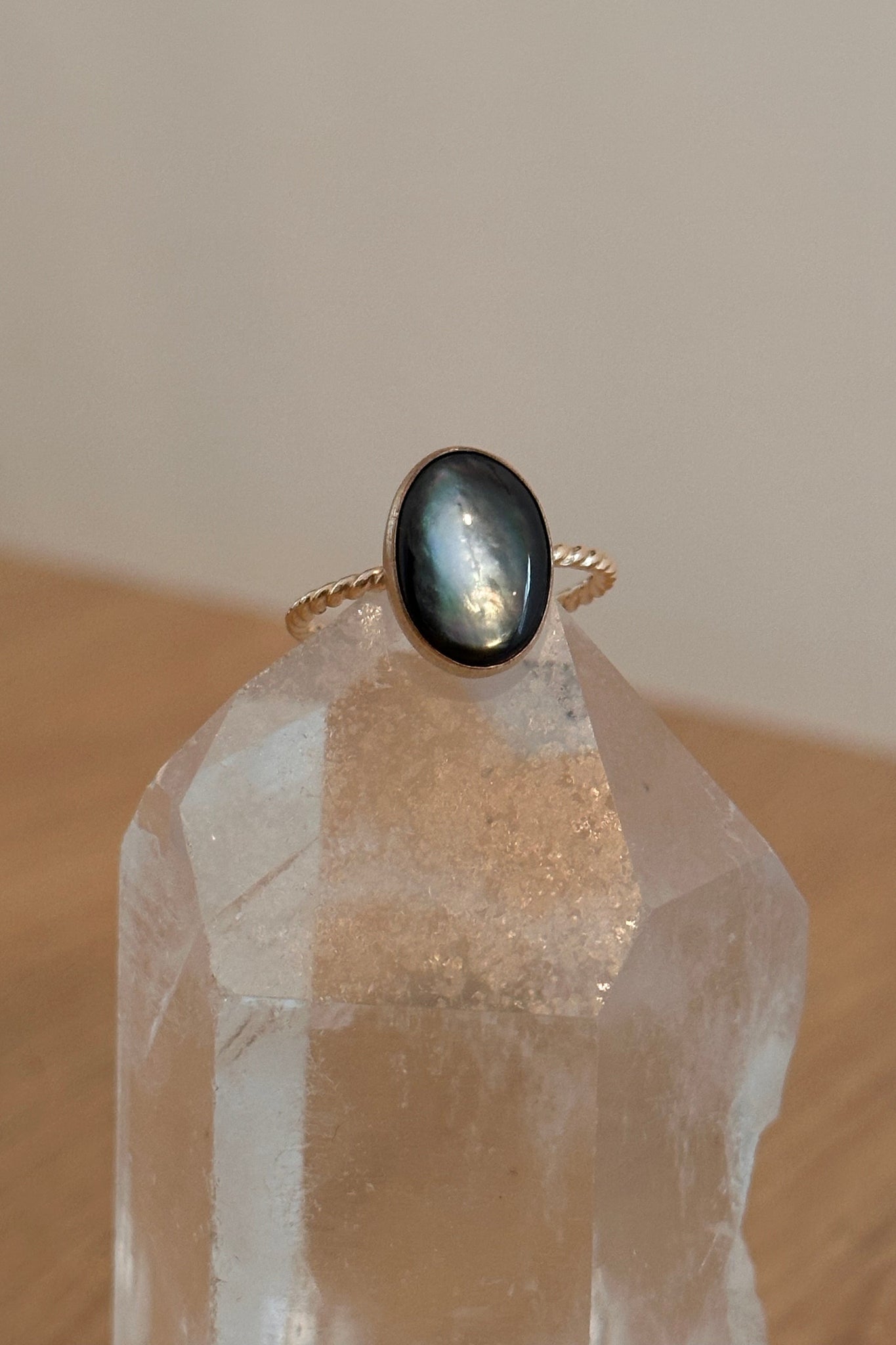 Gold ring with a black stone on a clear crystal