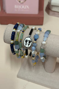 Stack of beaded bracelets on a gray cushion with a blurred background