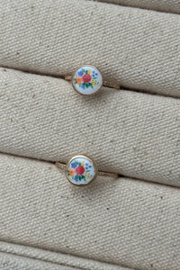 vintage floral design ring on a textured beige surface