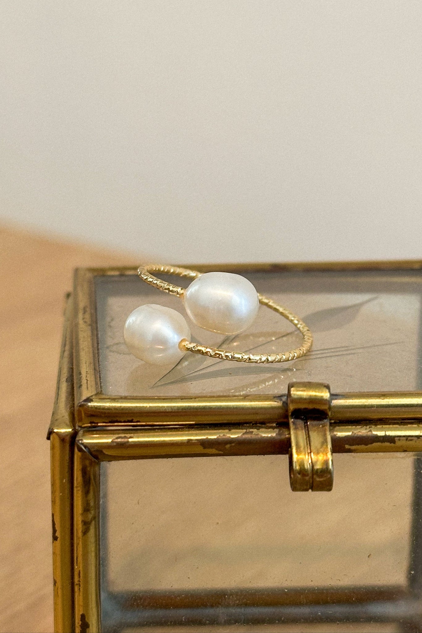 Gold ring with pearls on a glass box
