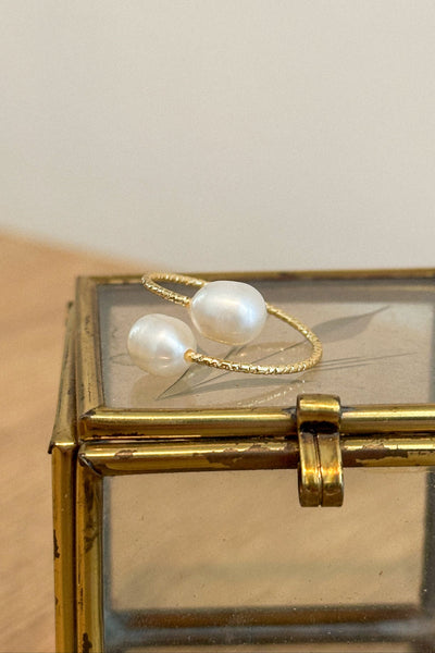 Gold ring with pearls on a glass box