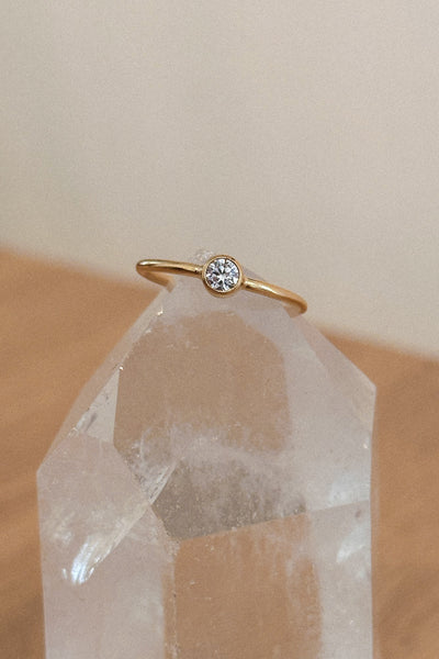 Gold ring with a cz on a quartz crystal with a neutral background