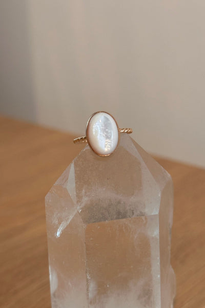 Gold ring with a mother of pearl on a crystal prism