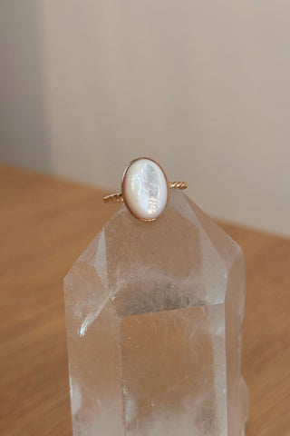 Gold ring with a mother of pearl on a crystal prism