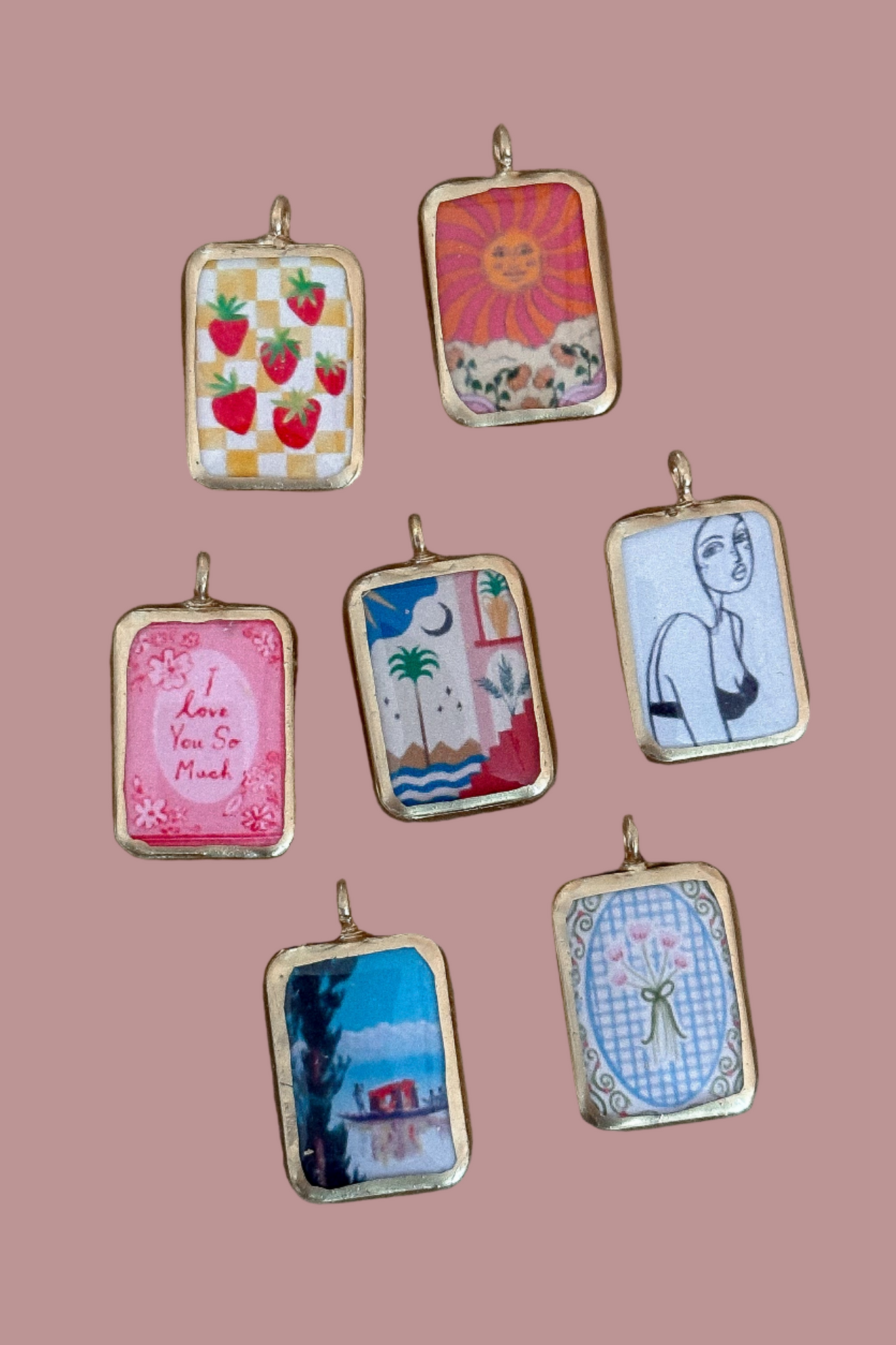 Set of small rectangular pendants with various designs on a wooden surface