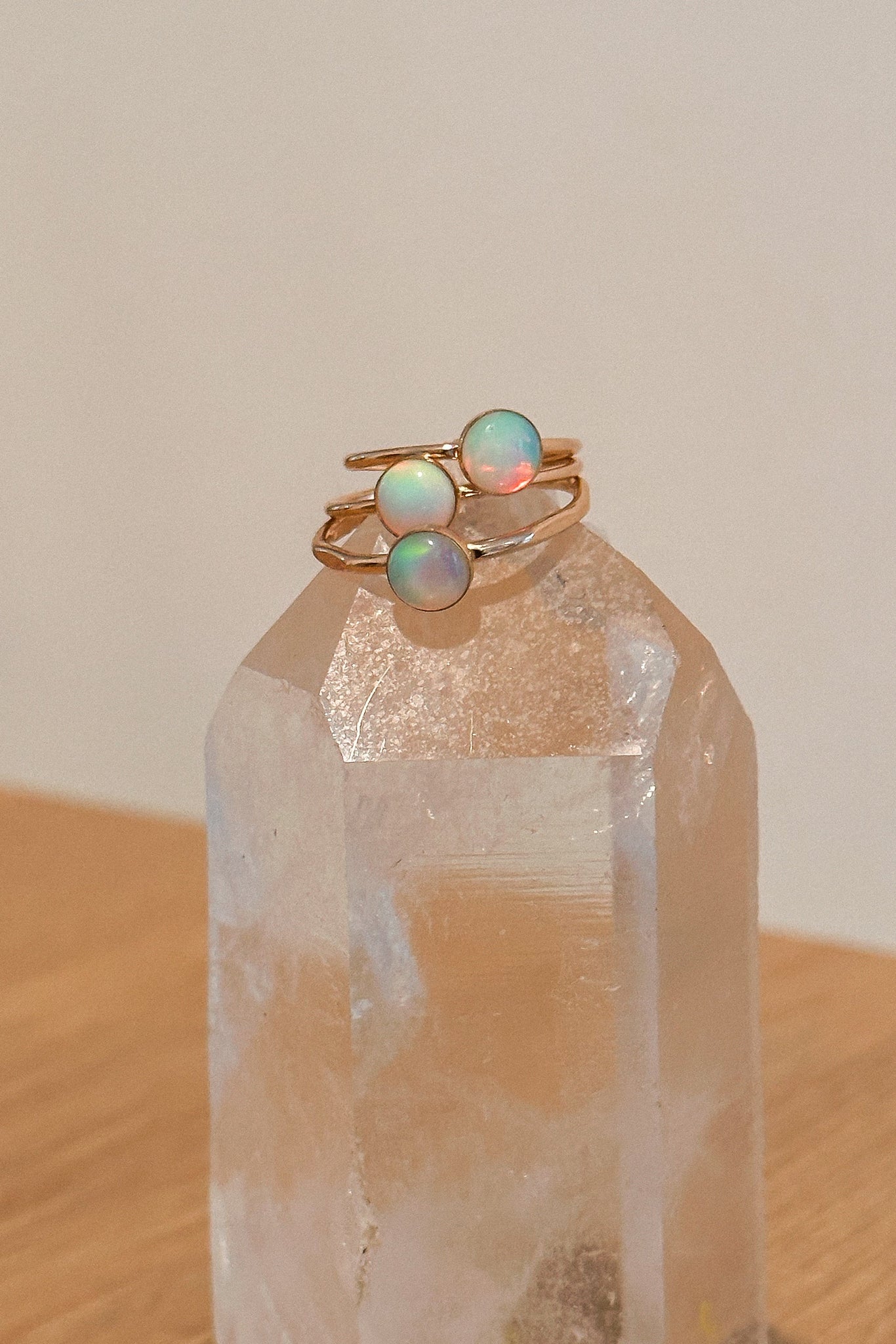 Two gold rings with opal stones on a clear crystal prism