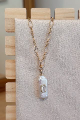 Necklace with a pendant on a gray fabric background